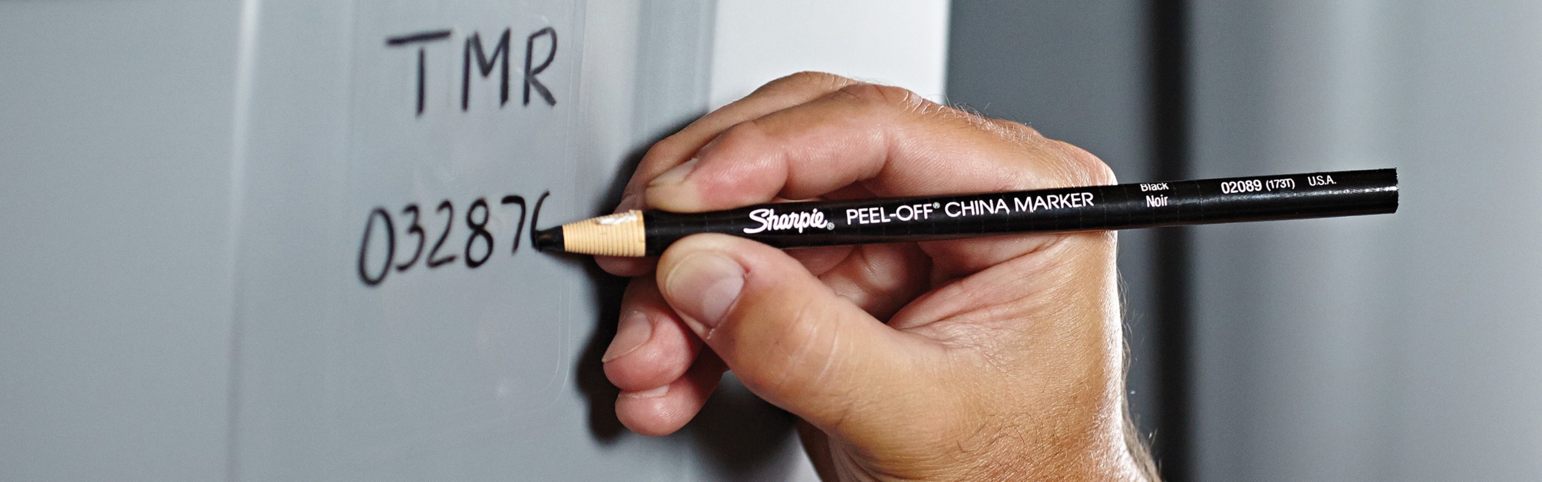 person writing with peel off china marker