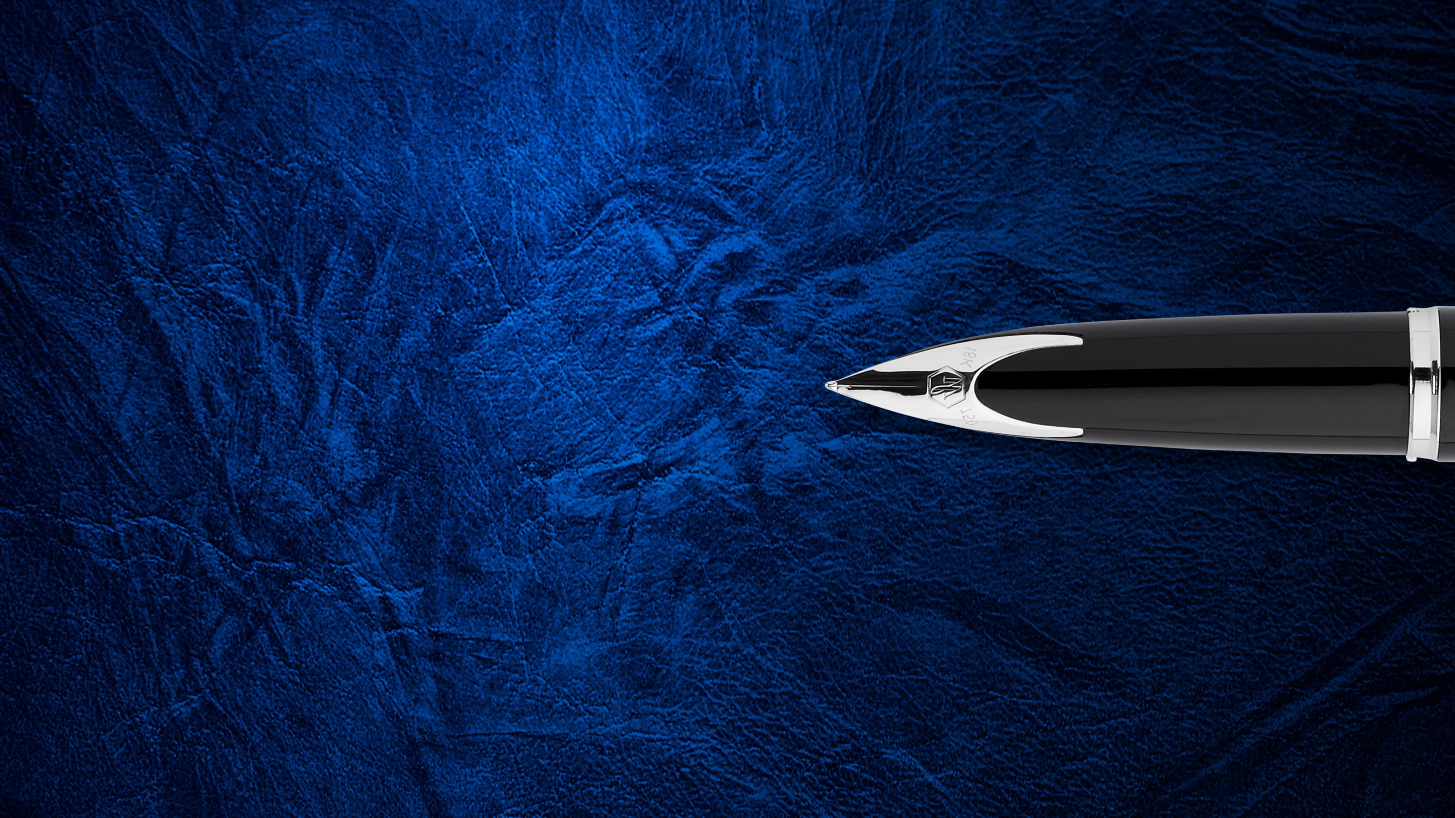 Closeup of a Carene fountain pen nib over a textured background.