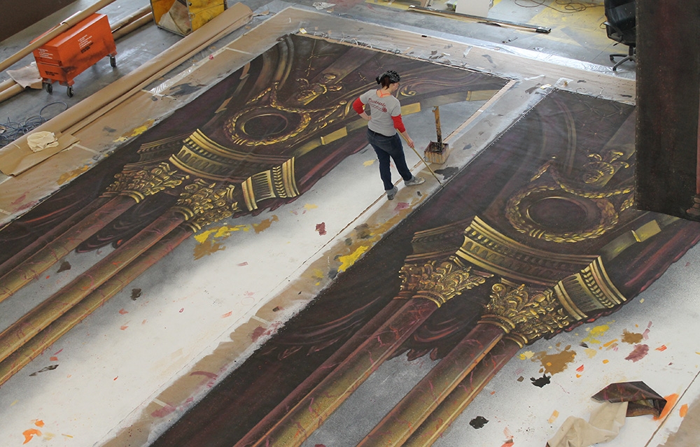 scenic artist painting extra-wide canvas
