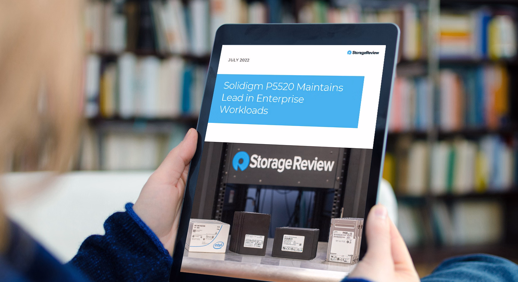 Person holding ipad with StorageReview article titled Solidigm P5520 Maintains Lead in Enterprise Workloads
