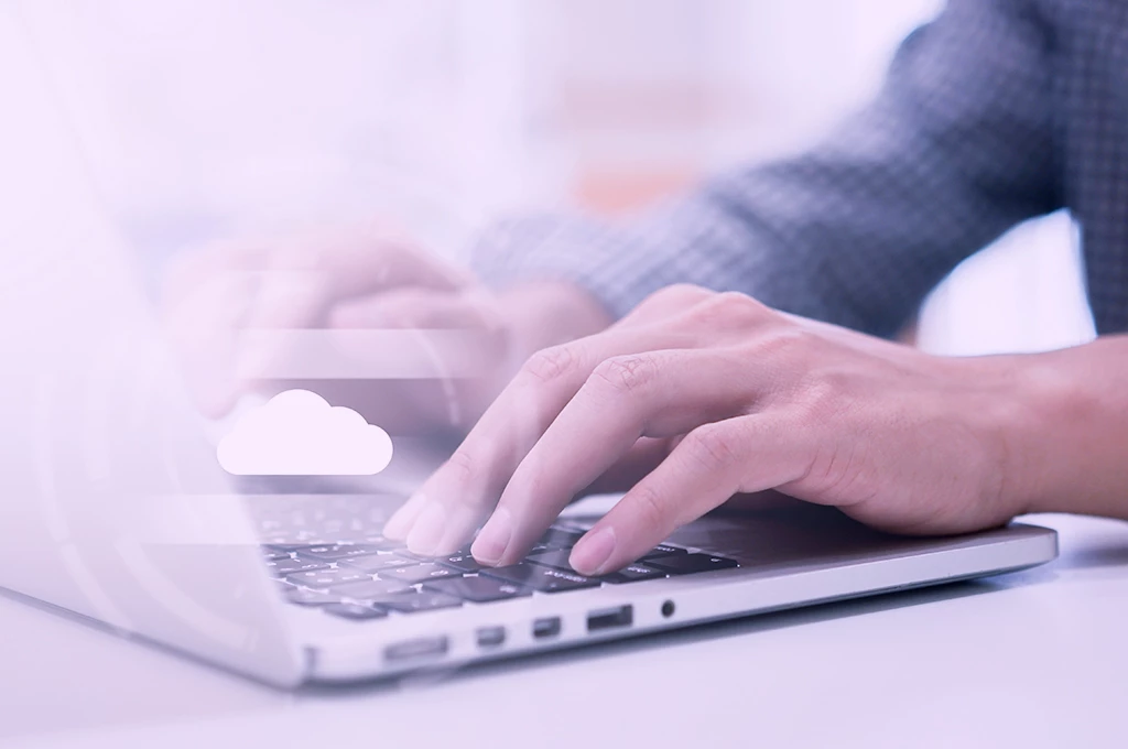 Hands of PC user with overlay of cloud storage icon symbolizes way to protect photos and files with a cloud data backup plan