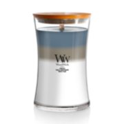 woodwick unchartered waters large hourglass trilogy candle featuring layered scents of tempest, sand & driftwood, and white teak