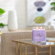 lilac blossoms signature medium jar candle lit on side table image number 3