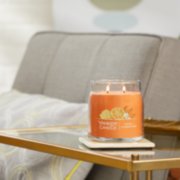 honey clementine signature medium jar candle lit on side table image number 3