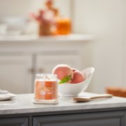 farm fresh peach signature medium jar candle on kitchen counter image number 3
