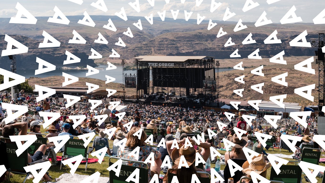 The Gorge outdoor concert theater, people seated in the crowd; White AAA WA spiral graphic overlay
