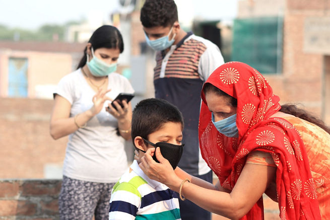 woman fixing the mask on a young boy