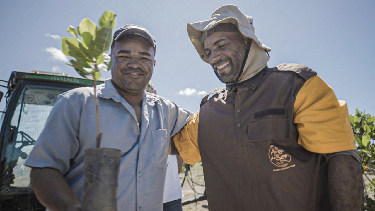2 Brazilian Farmers holding a plant
