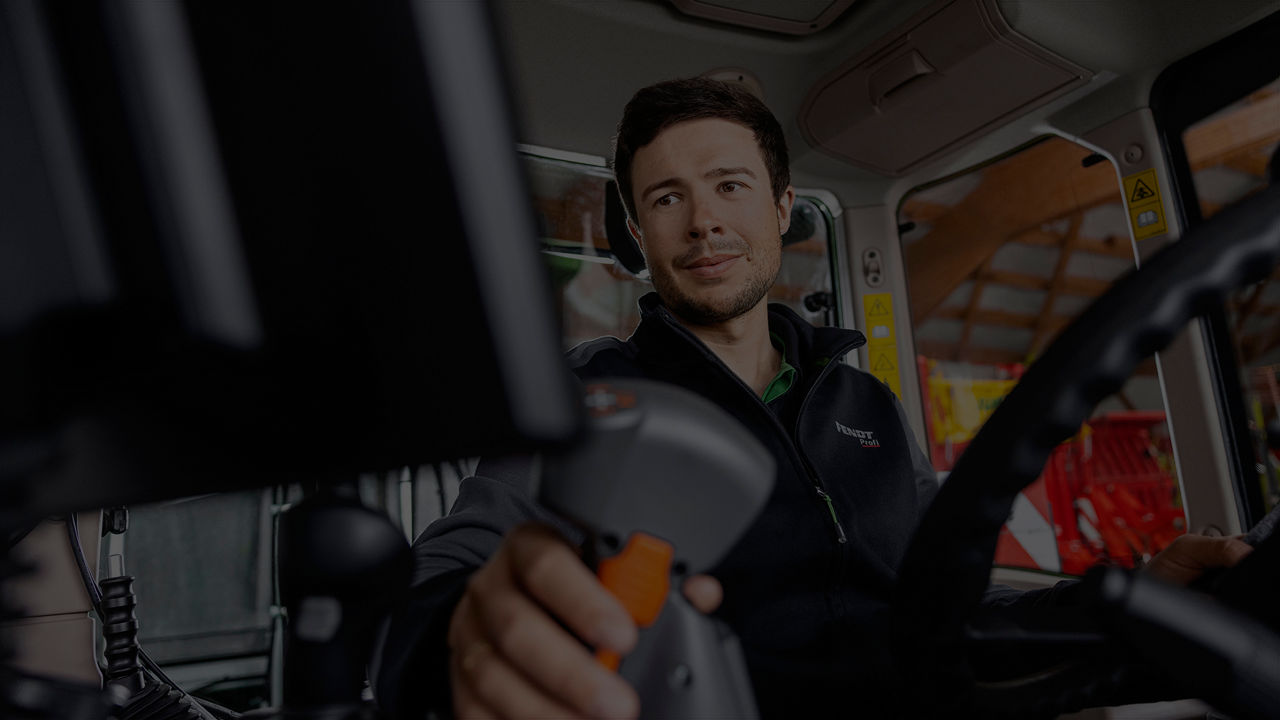 An operator using a motec camera in a tractor cab