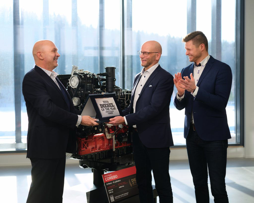 Company representatives presenting an award beside an AGCO Power CORE80 engine display.