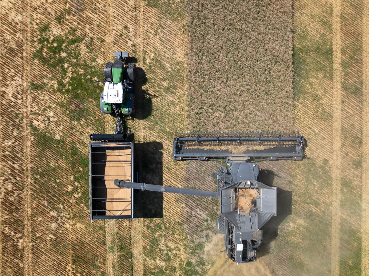 A combine harvests into a grain cart controlled by OutRun technology