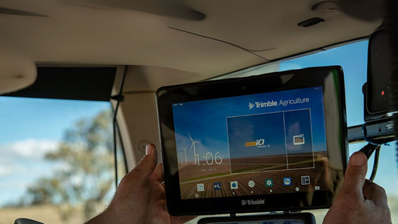 Farmer using PTxTrimble technology in the tractor cab