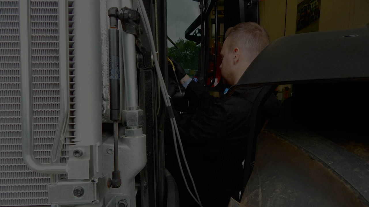 Technician inspecting heavy machinery outdoors