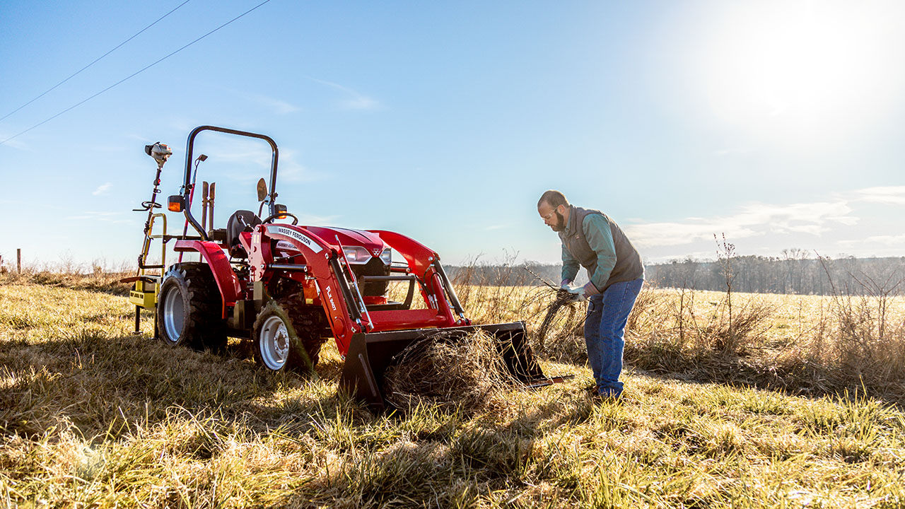 Man loading hay into a Massey ferguson 1800 E series tractor