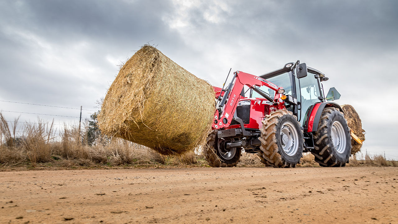 Massey ferguson 4700 series tractor hauling hay bale