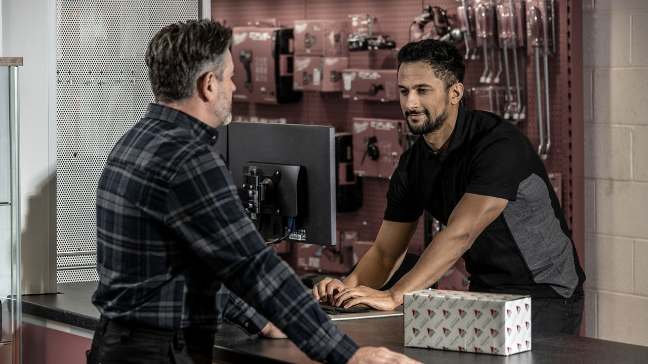 A farmer discussing parts with an employee at a dealer