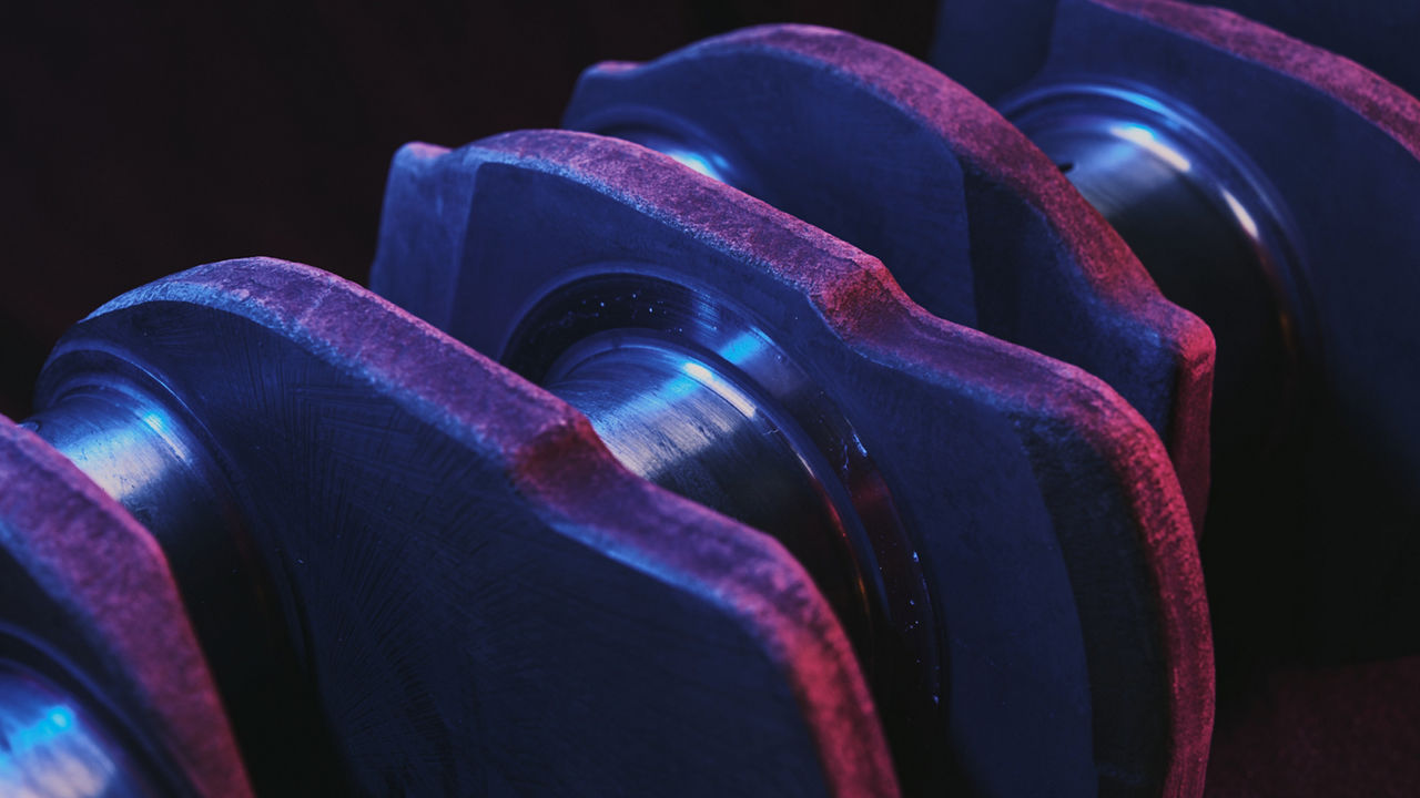 A close up of a crankshaft with pistons attached