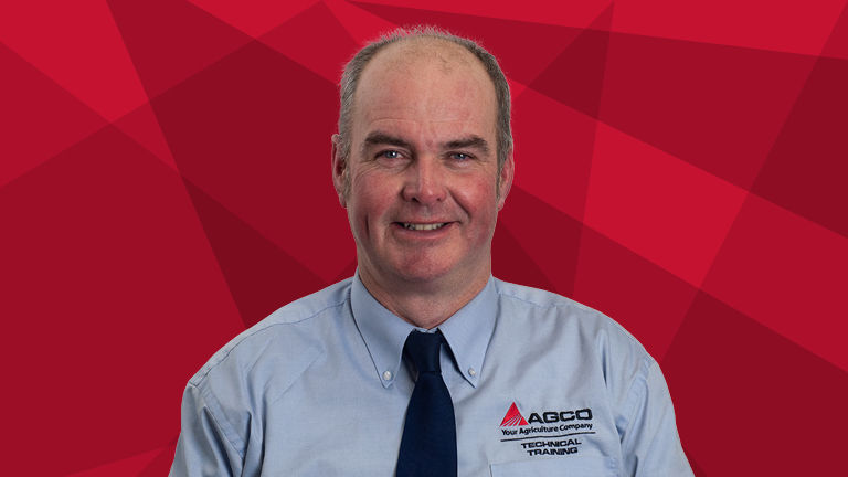 A headshot of Charlie Rollason on a red background