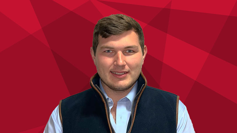 A headshot of Luke Waldram on a red background