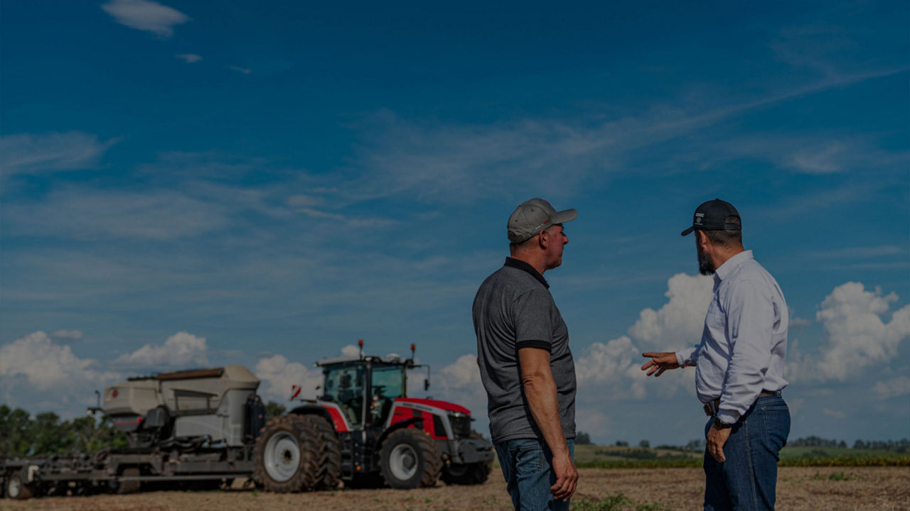 MF planting with two farmers onlooking