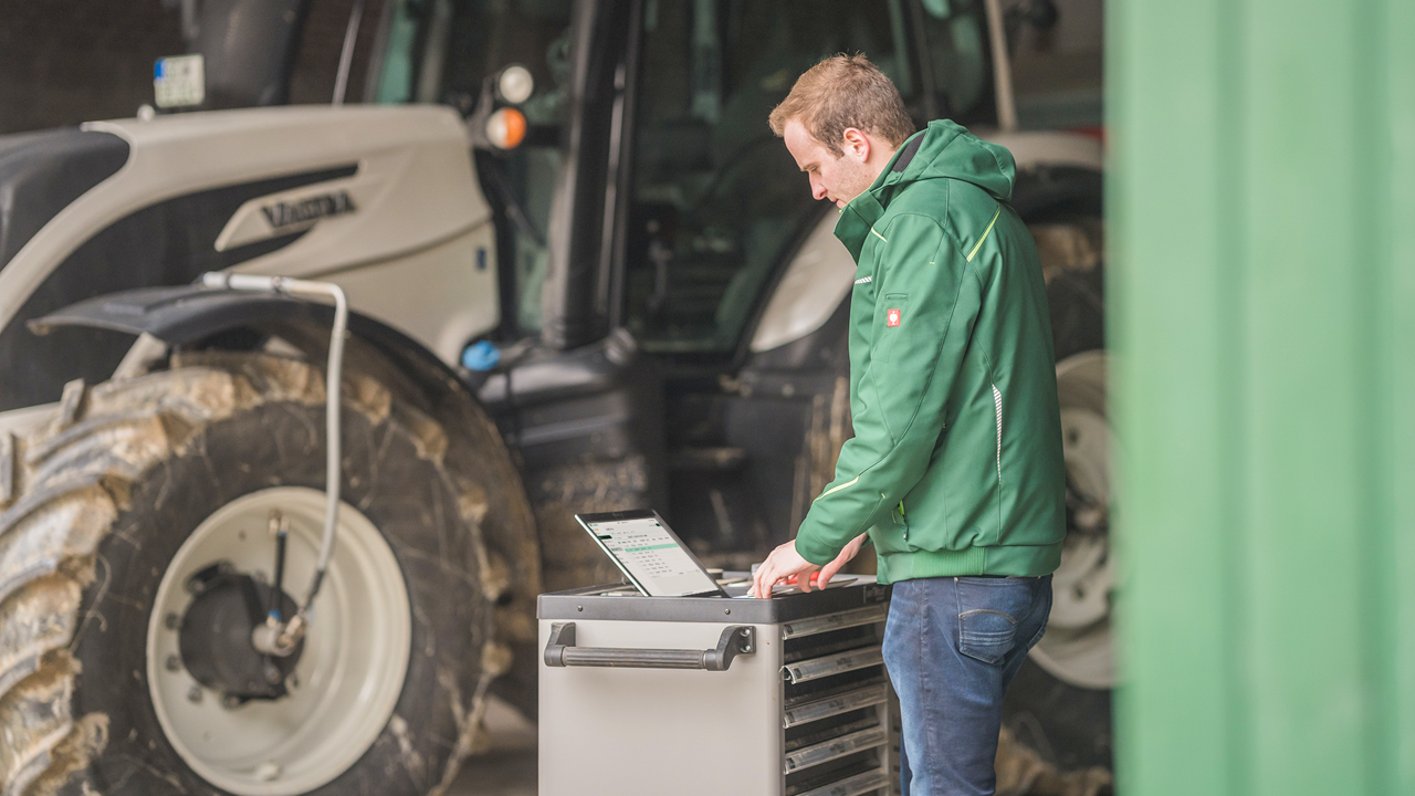A man uses PTx FarmENGAGE on a laptop in the farm shop