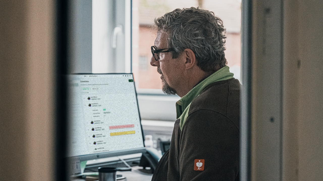 A man uses PTx FarmENGAGE on the computer in his office