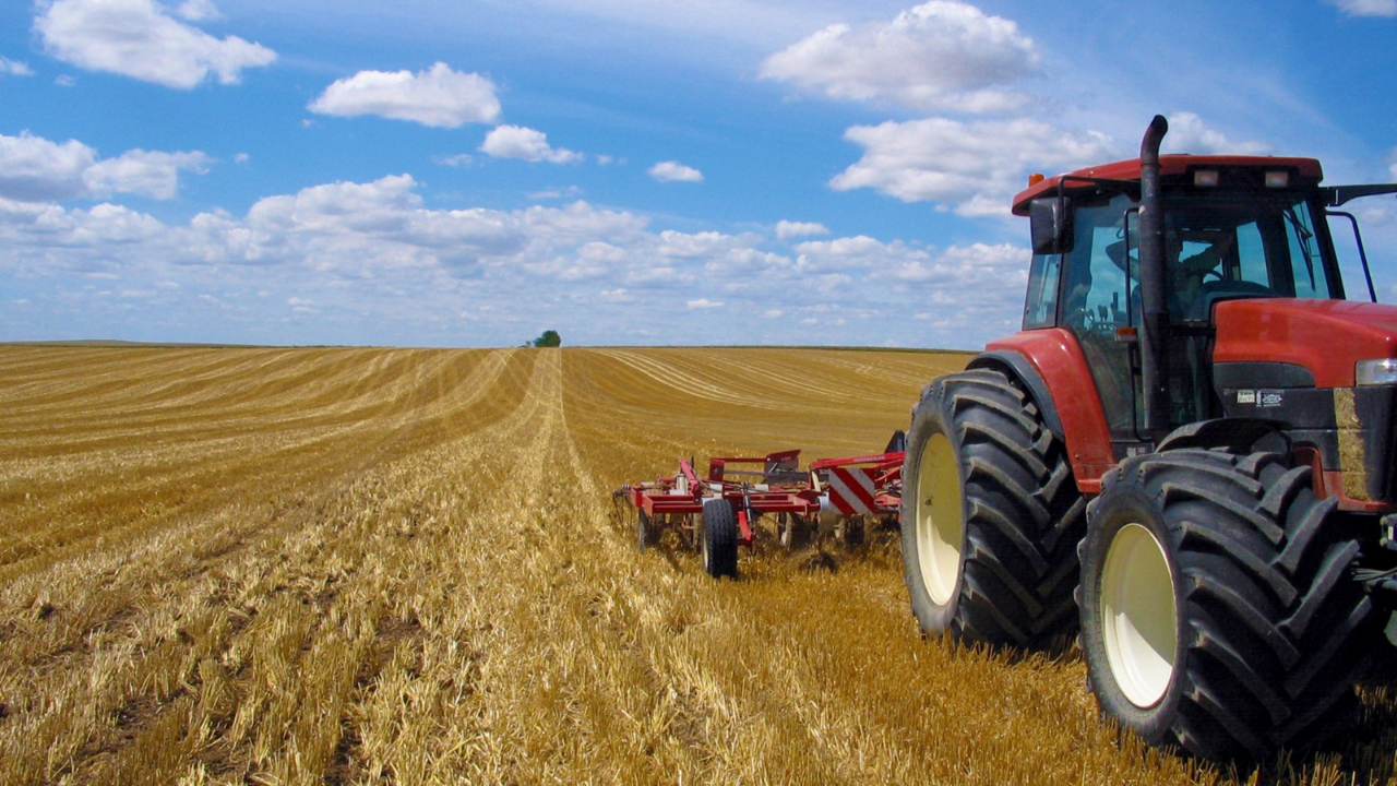 A red tractor working a field