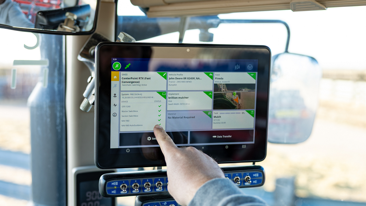 A farmer uses a PTx Trimble GFX display in their tractor.