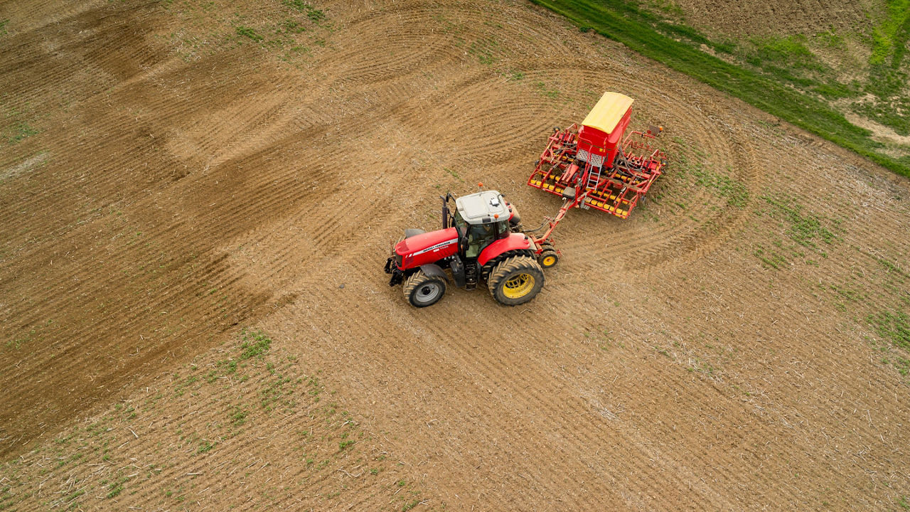 A farmer in a field using PTxTrimble technology during harvest