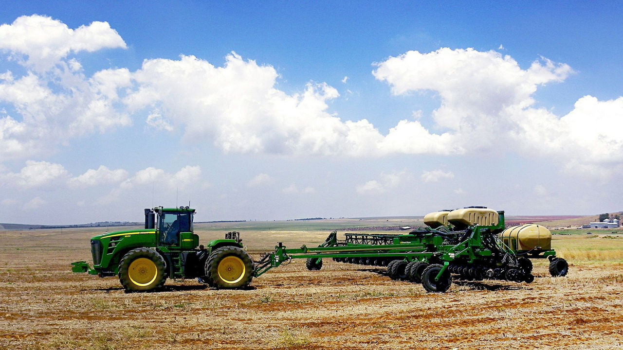 Green tractor planting in rows
