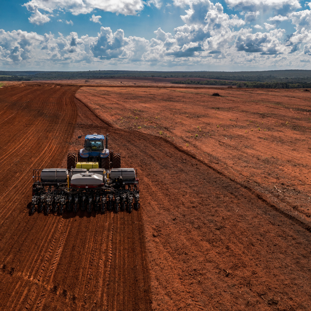 A tractor plants a field.