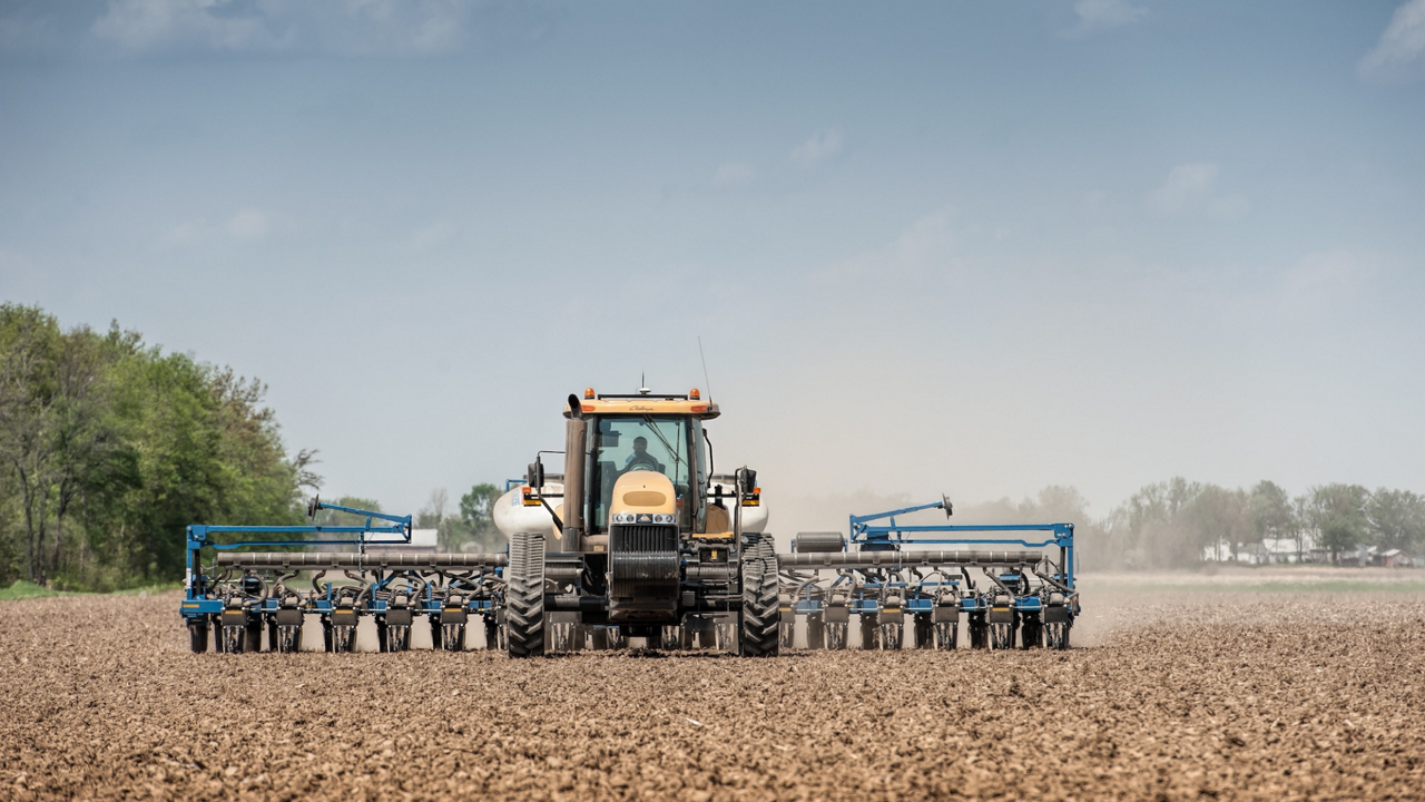 Farmer with hand on steering wheel in tractor cab with GFX-350 display.