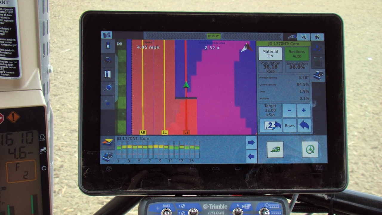 Farmer with hand on steering wheel in tractor cab with GFX-350 display.