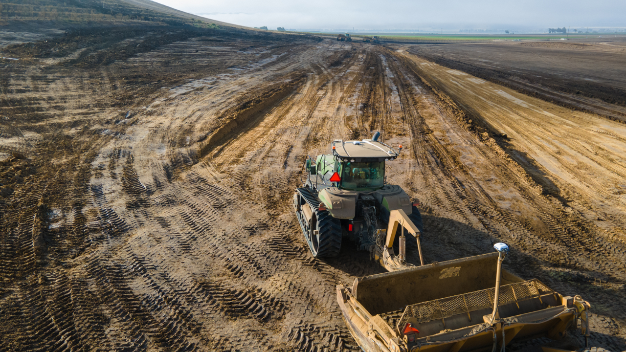 A tractor and grader form land