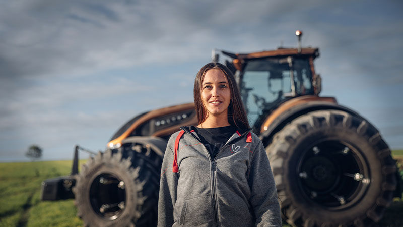 A Valtra driver stands in front of their S Series idling in the background