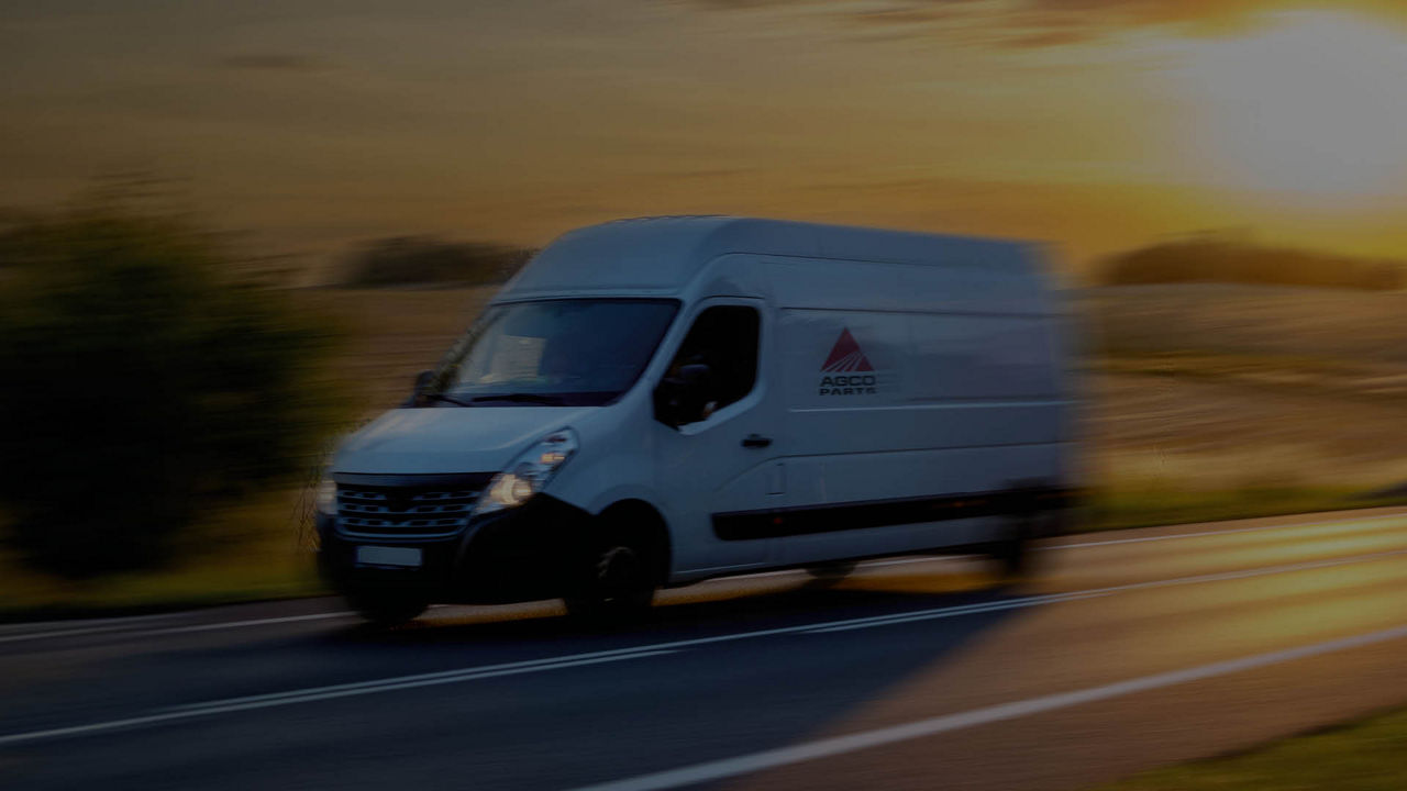 A van speeding down a road with the sun rising in the background