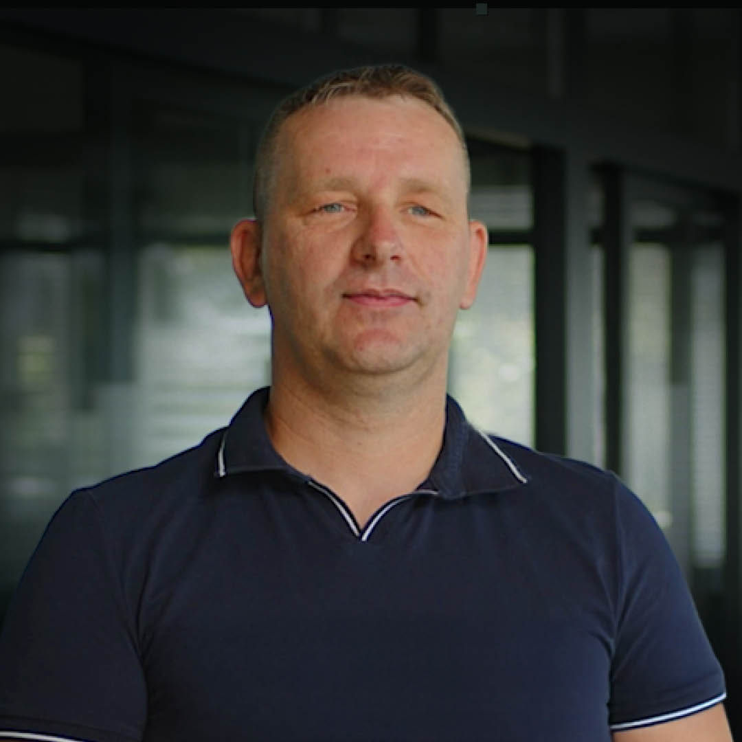 A headshot of Daniel Kierchner with an office in the background