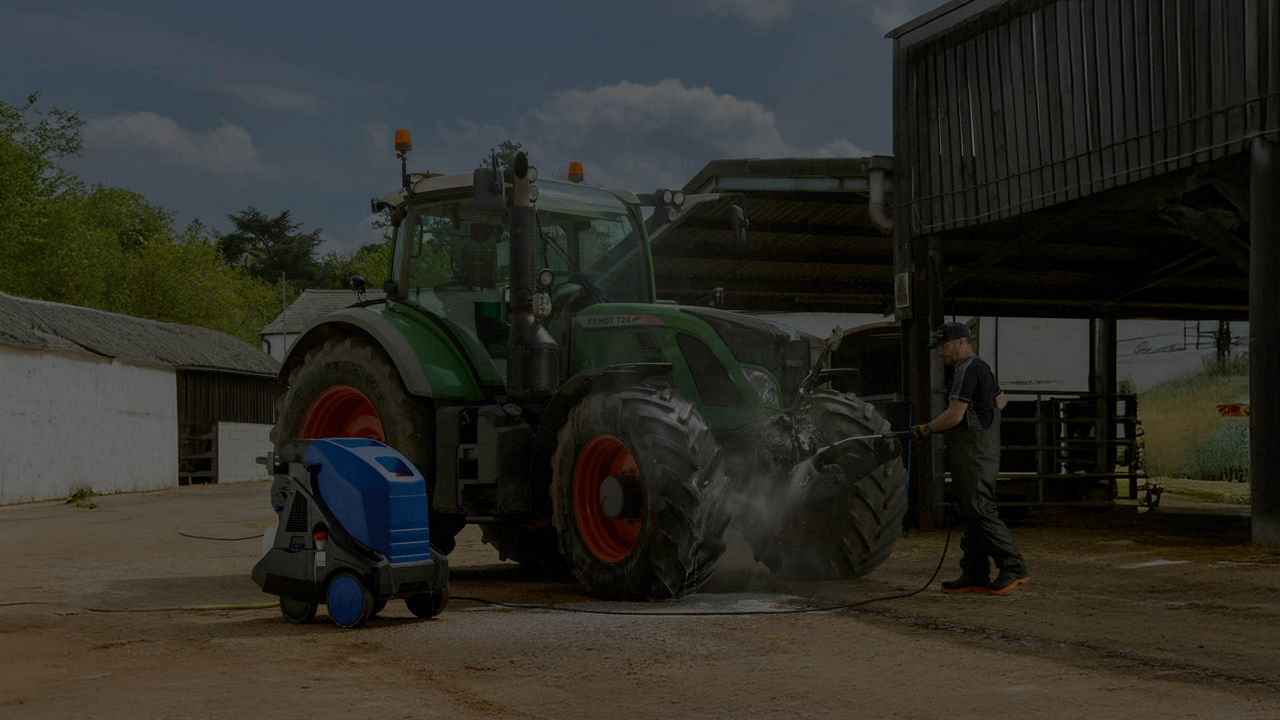 A dark picture of a Fendt tractor in a farmyard