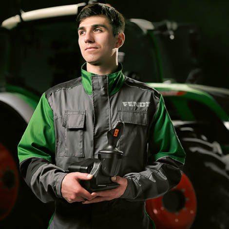 A technician in Fendt overalls holding a part