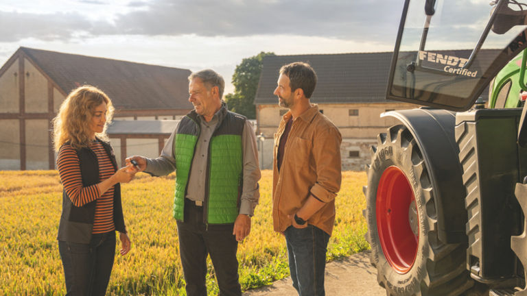 Trois personnes discutant près d’un tracteur Fendt Certified