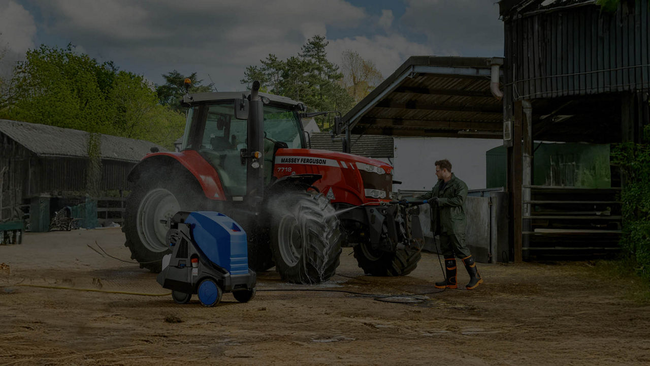 A dark picture of a Massey Ferguson tractor in a farmyard