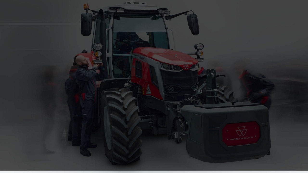 A dark version of an MF tractor being worked on by various techs
