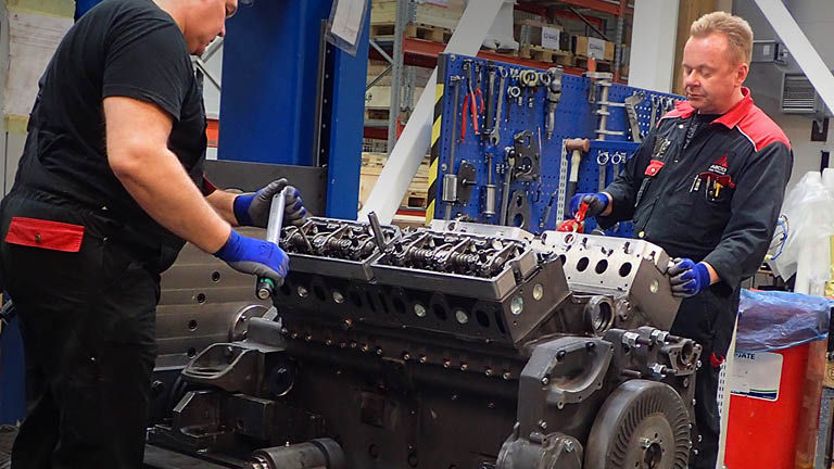 Two technicians working on an engine block