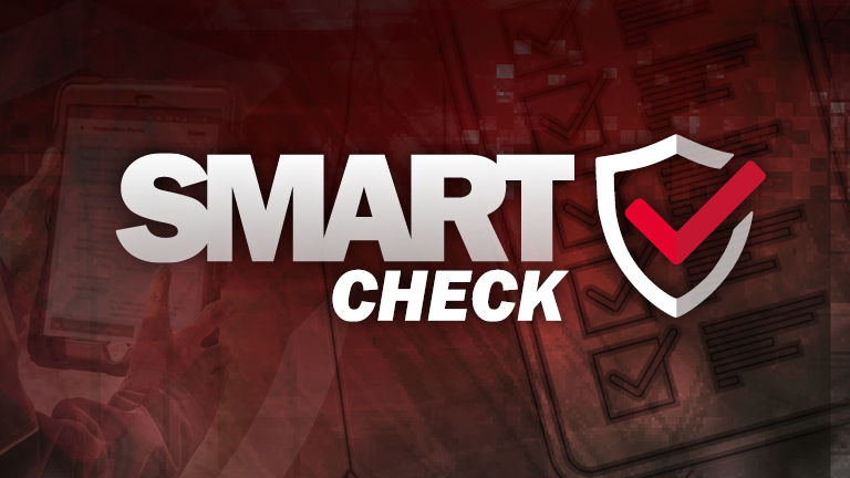 A technician checking a clipboard with the SMART Check logo