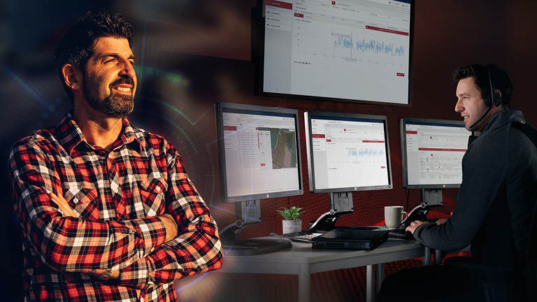 A satisfied looking farmer is on the left, on the right is a tech working on a computer