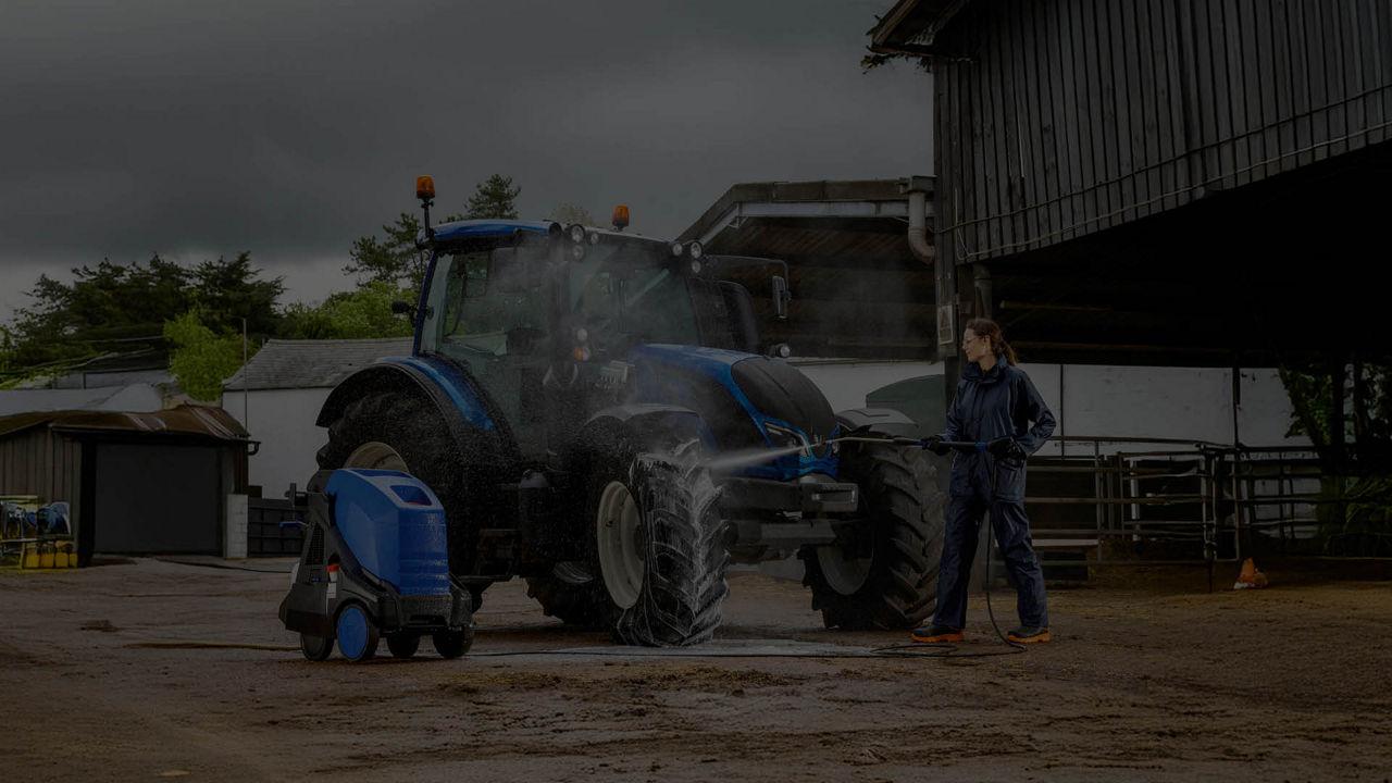 A dark picture of a Valtra tractor at a farm