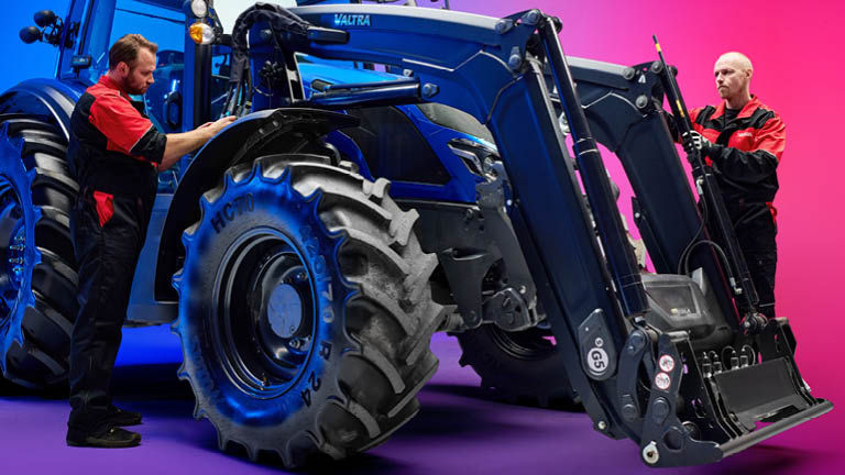 Two technicans fitting a front loader to a Valtra tractor