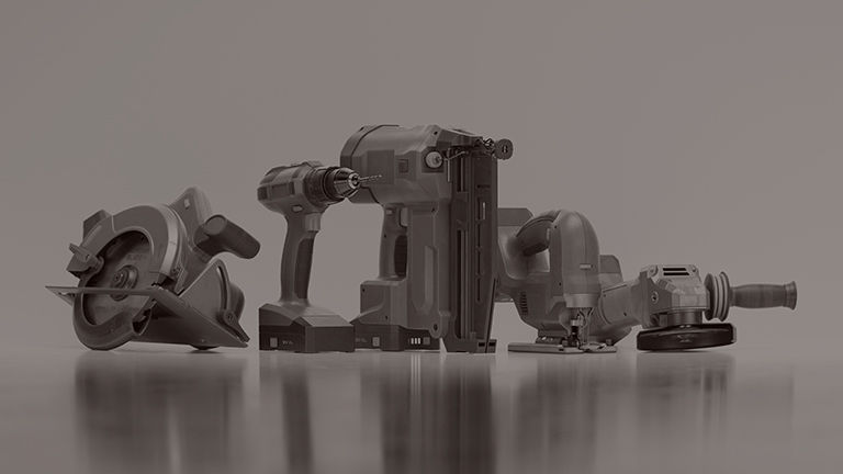 Various power tools on a grey background