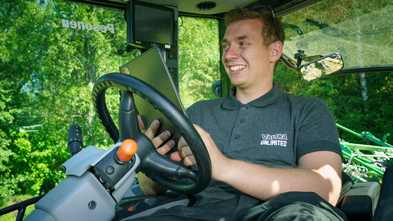 A smiling man driving a tractor