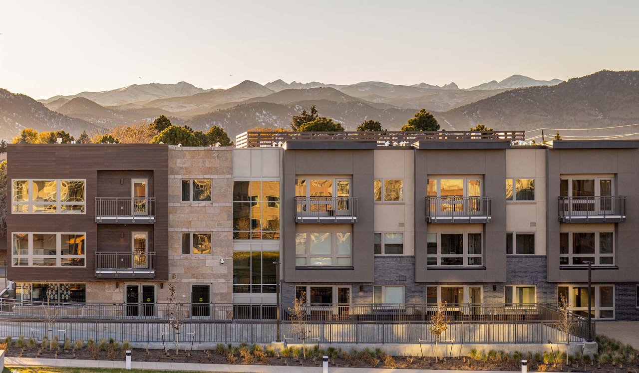 Drone view of Parc Mosaic apartments at sunset with the mountains in the background